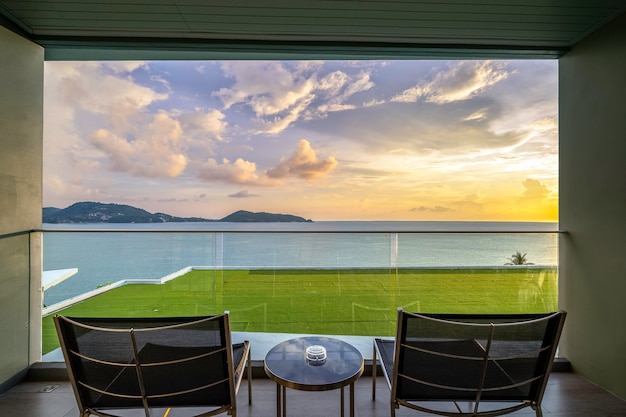 Tafel en stoelen op een balkon met uitzicht op zee, vlakbij de zee.