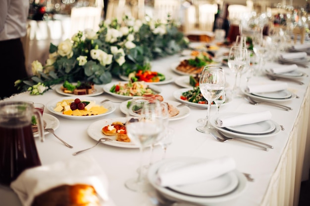 Tafel gedekt op een huwelijksreceptie versierd met bloemen heerlijk eten en drinken