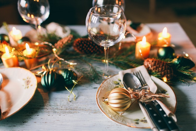 Tafel geserveerd voor winterdiner in de woonkamer. Close-up weergave, tabel instelling. Kerst- en winterdecoraties.