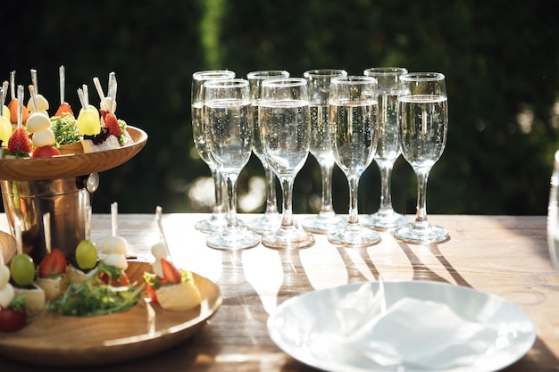 Tafel met diverse hapjes broodjes aardbeien en champagneglazen Buffet voor bruiloftsgasten