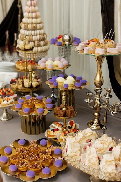 Tafel met gebak snoep snoep buffet Desserttafel voor een feest lekkernijen voor het bruiloftsbanket gebied Close-up candy bar Heerlijk gedecoreerd