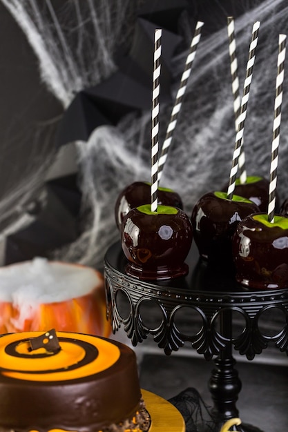 Tafel met gekleurde snoepappels en cake voor Halloween-feest.