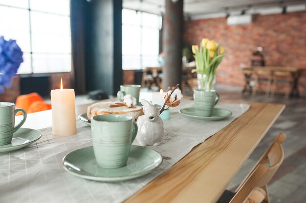 Tafel met kopjes en platen op rustieke achtergrond. Loft interieur.