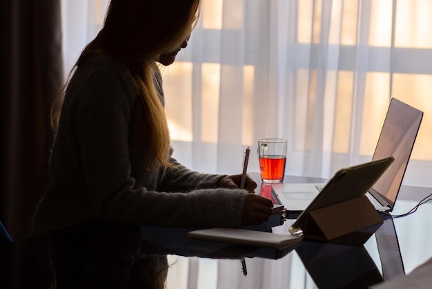 Tafel met laptop en thee werkplek vanuit huis werk aan de thuistafel in de oorlog werktafel van