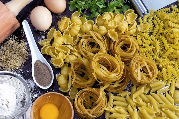 Tafel met pasta en ingrediënten om ze te maken Bovenaanzicht