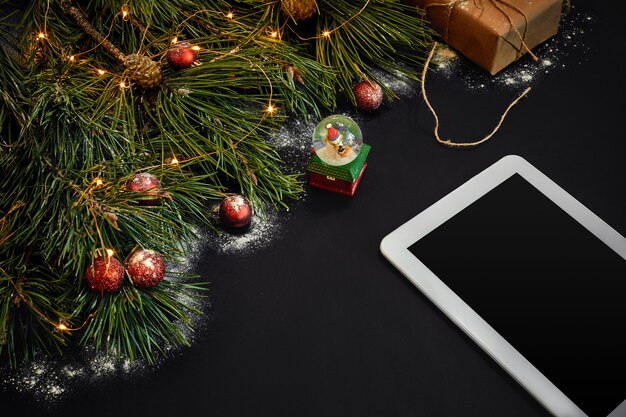 Tafel met tabletcomputer kerstspeelgoed sterren en pluizige dennentakken vrije ruimte voor tekst bovenaanzicht