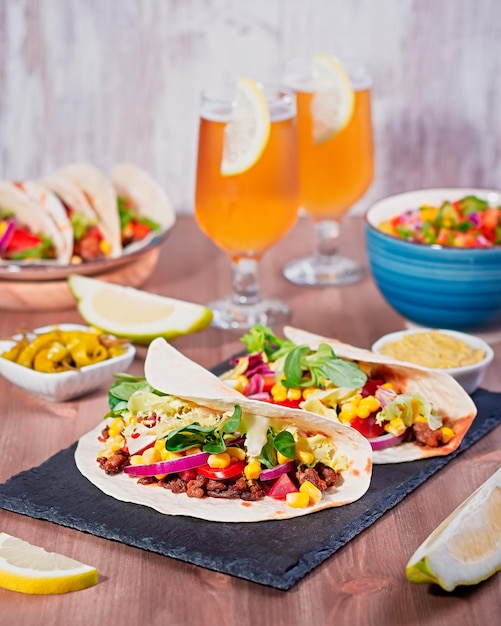 Tafel met taco's mango salsa nacho's met saus guacamole citroen bier voor Cinco de Mayo feest Voorgerechten en traditionele Mexicaanse gerechten voor familiediner op houten tafelblad kopie ruimte