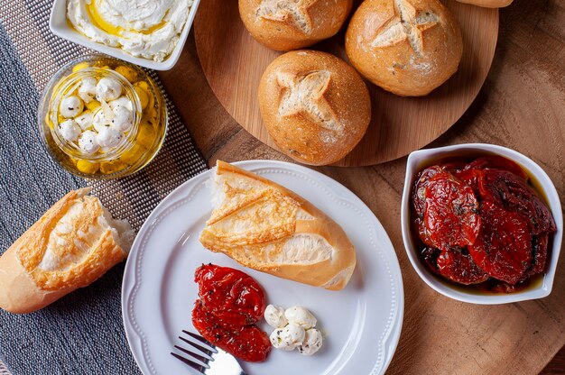 Tafel met verschillende voorgerechten. Diverse soorten brood, zongedroogde tomaten, twee soorten wrongel.