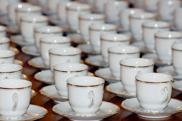 Foto tafel vol met koffiekopjes en schotels met gouden rand