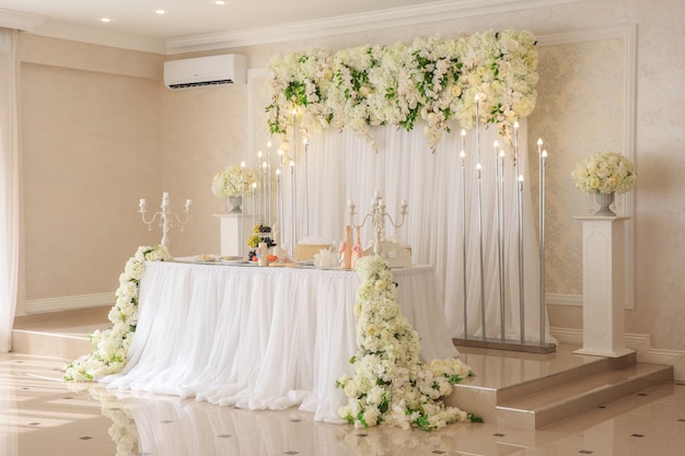 Tafeldecoratie bruiloft met florale decoraties en kaarsen, gloeilampen