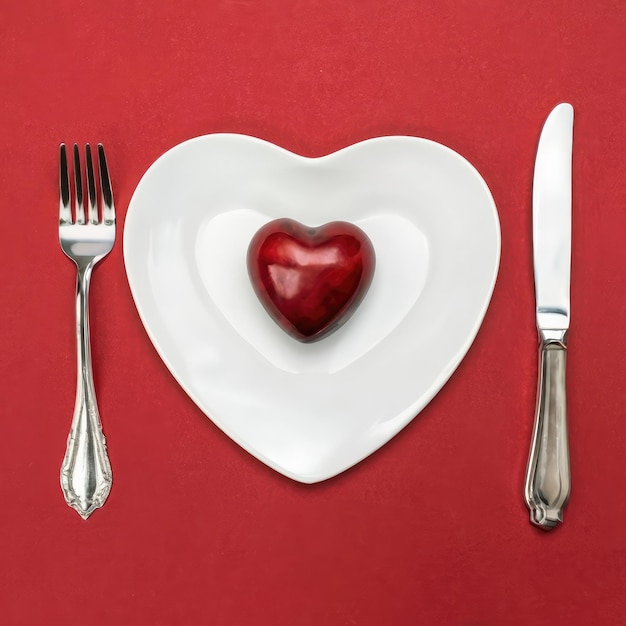 tafelmes en vork op rood bord in de vorm van een hart