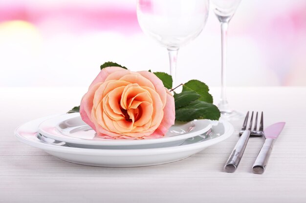 Tafelopstelling met roze roos op bord