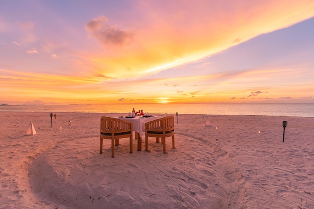 Tafelopstelling voor huwelijksceremonie op sunset beach Romantische bestemming dinerpaar jubileum