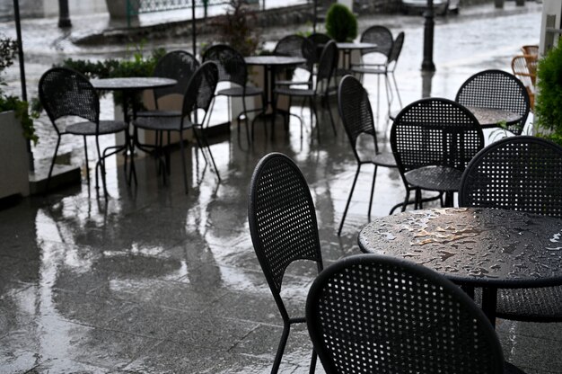 Tafels en stoelen van een straatcafé nat van de regen