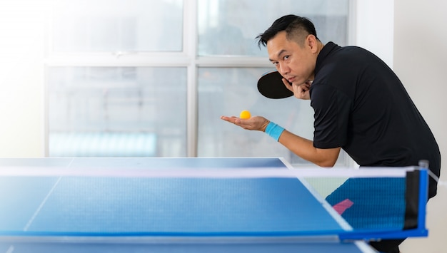 Tafeltennistafel, man tafeltennis spelen met racket en bal in een sporthal