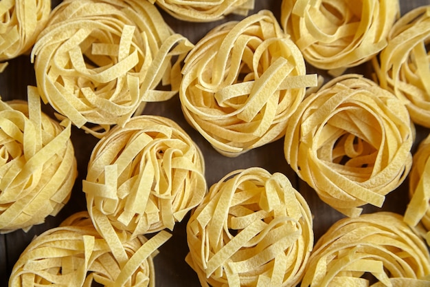 Foto tagliatelle italiaanse pasta op bruine houten tafel