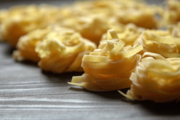 Tagliatelle Italian pasta on brown wooden table