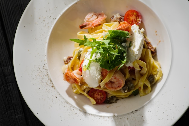 Tagliatelle met garnalen, rucola, tomaten en Philadelphia-kaas.