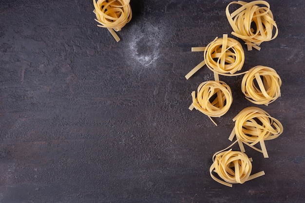 Tagliatelle pasta op bruin getextureerde stenen kopie ruimte