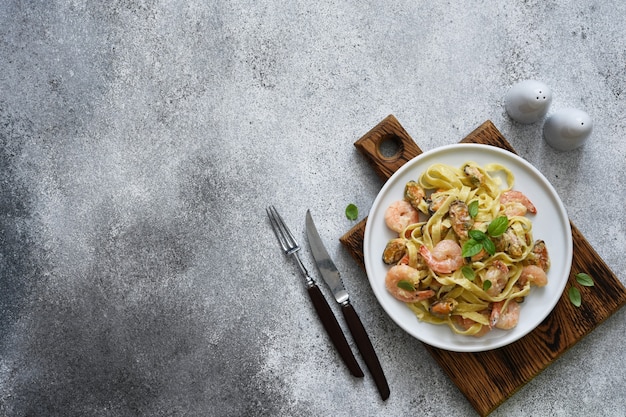 Tagliatelle pasta with seafood and parmesan in a plate view from above