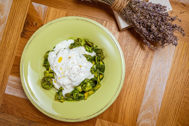 Tagliatelle pasta with spinach and green pea pesto selective focus