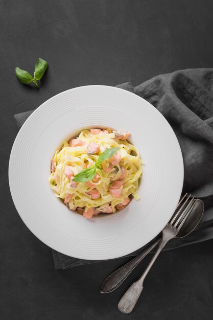 Tagliatelle van deegwaren met forel en room op zwarte. Heerlijke mediterrane lunch.