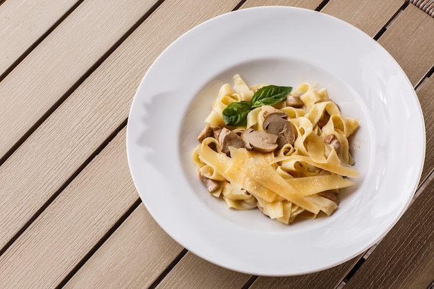 Tagliatelle vegetarian Pasta Dish with Mushrooms decorated with basil.