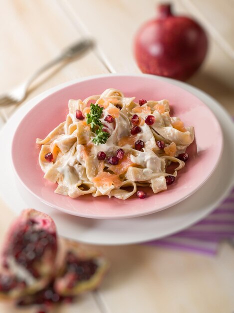 Tagliatelle with salmon pomegranate and cream sauceselective focus