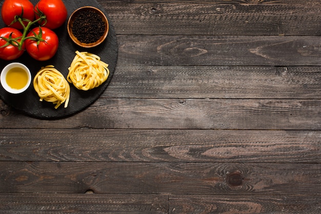 Tagliatelle with tomato and basil, made at home, on a wooden surface.