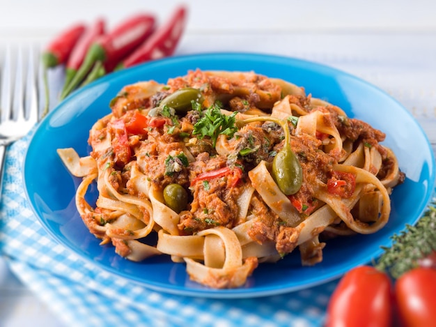 Tagliatelle with tuna tomatoes and capers selective focus