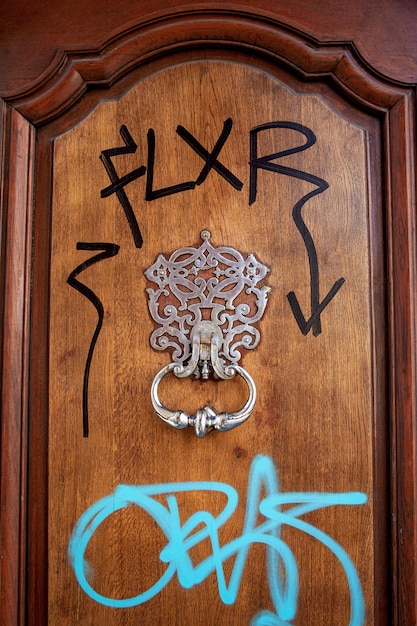 Tags on a wooden door with metal knocker