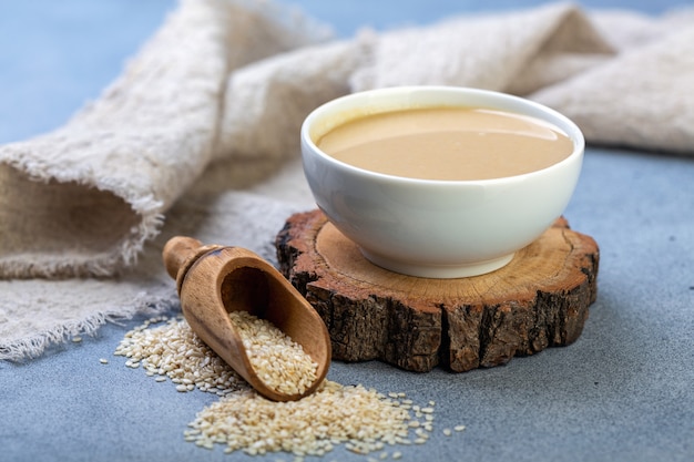 Tahini in a bowl and a scoop with sesame