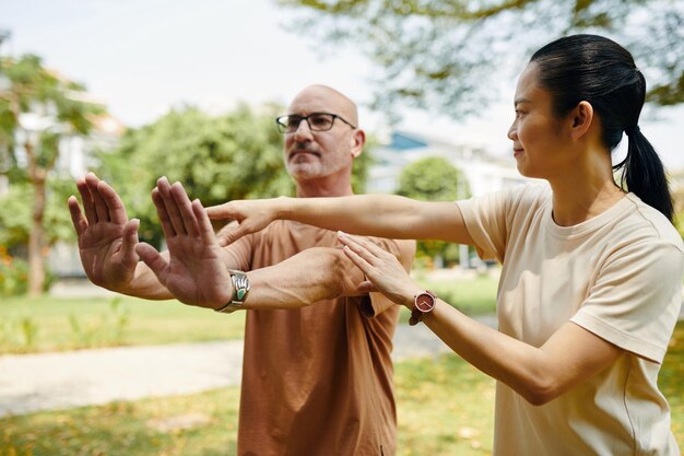 Tai chi instructor working with client