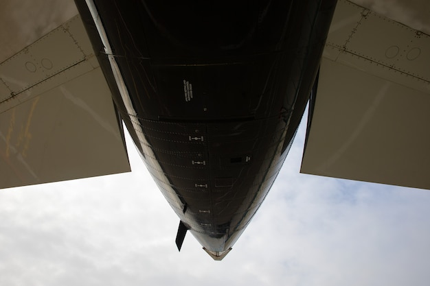 Photo tail of a business jet close-up on background of clouds