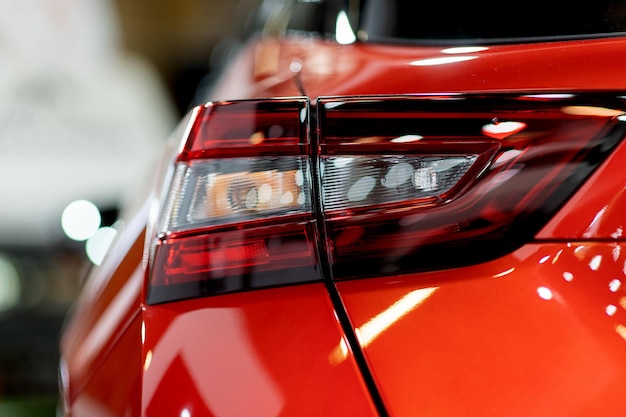 Tail light of nice and new orange sport suv car in modern garage