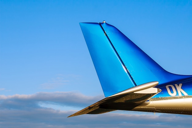 青い空を背景にした2人乗りの小型航空機の尾。閉じる。