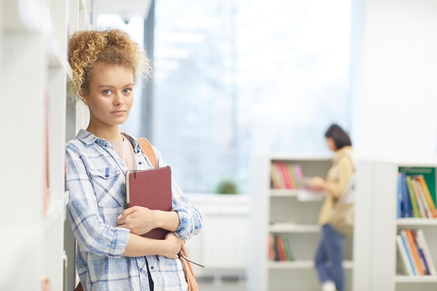 Taille-omhoog portret van het blonde vrouwelijke boek van de studentenholding