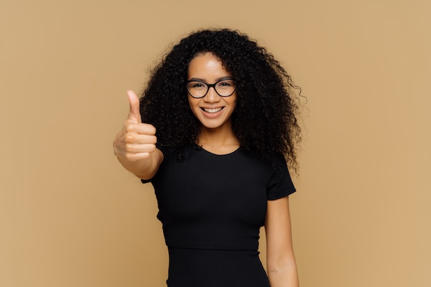 Taille omhoog schot van tevreden ondersteunende vrouw toont duim omhoog, proost beste vriend