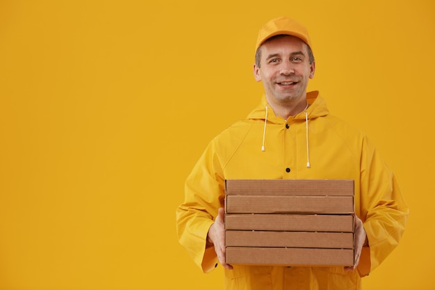 Taille-up portret van volwassen bezorger met pizzadozen