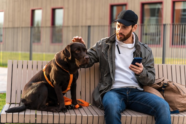 Taille-up portretweergave van de blanke man die aandachtig naar zijn hond kijkt en hem aait terwijl hij samen op straat zit Concept van huisdiereigenaren