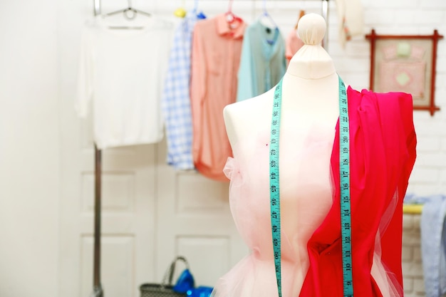 Tailor dummy with measuring tape in fashion studio