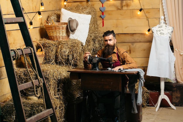 Tailor man sews clothes