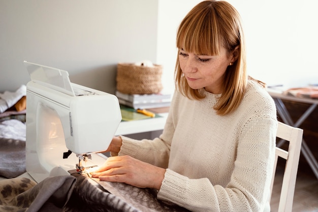 Donna su misura utilizzando strumenti per cucire tessuti