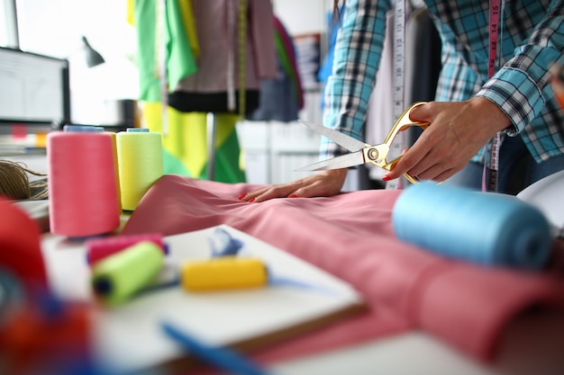 Tailor work with natural fabric in sewing workshop