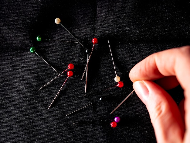 Tailors pins on black, top view.