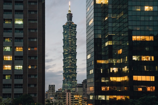 Taipei 101 Skyscraper at dusk with commercial buildings in foreground.