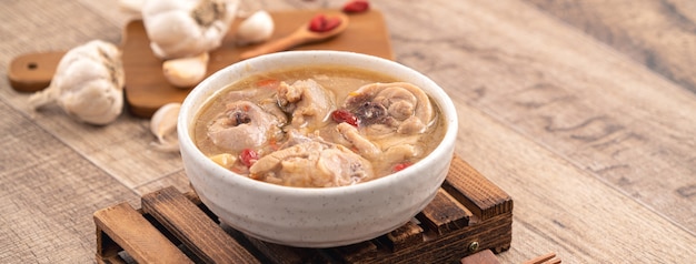 Taiwanees eten - zelfgemaakte heerlijke knoflook kippensoep in een kom op donkere houten tafel achtergrond.