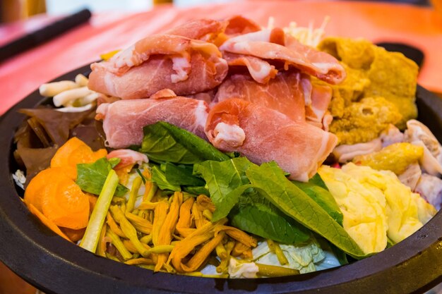 Taiwanese Cuisine Hot Pot with Pork Bacon Slices Vegetables and Herbs