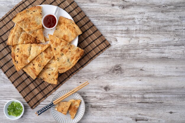 Photo taiwanese food delicious flaky scallion pie pancakes on bright wooden table background traditional snack in taiwan top view