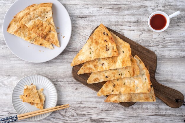 Taiwanese food delicious flaky scallion pie pancakes on bright wooden table background traditional snack in Taiwan top view